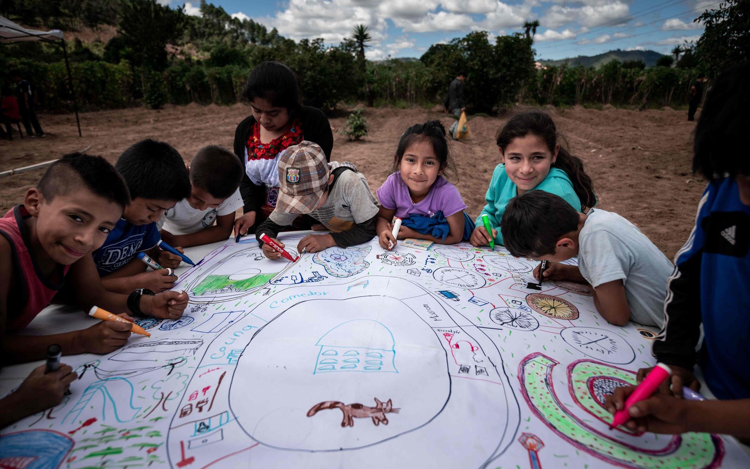 Reportage Guatemala; Foto: Kinder sitzen um ein großes Plakat herum und malen ihre Vorschläge (Quelle: Fabian Strauch / Kindernothilfe) Reportage Guatemala; Foto: Kinder sitzen um ein großes Plakat herum und malen ihre Vorschläge (Quelle: Fabian Strauch / Kindernothilfe)