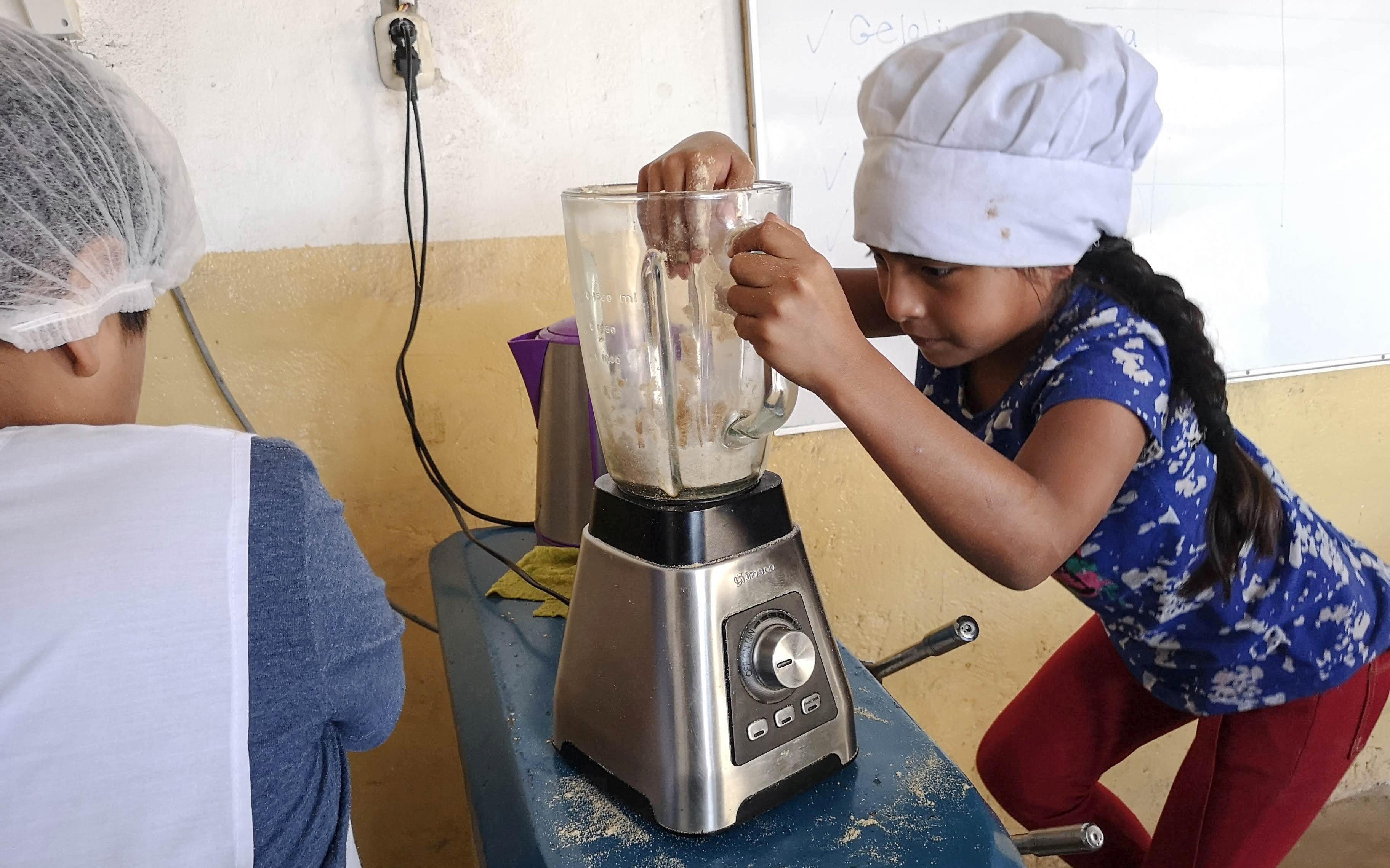 Reportage Peru: "Von Selbstvertrauen und Kinderrechten"; Foto: Zwei Kinder an einer Küchenmaschine (Quelle: Lorenz Töpperwien / Kindernothilfe)