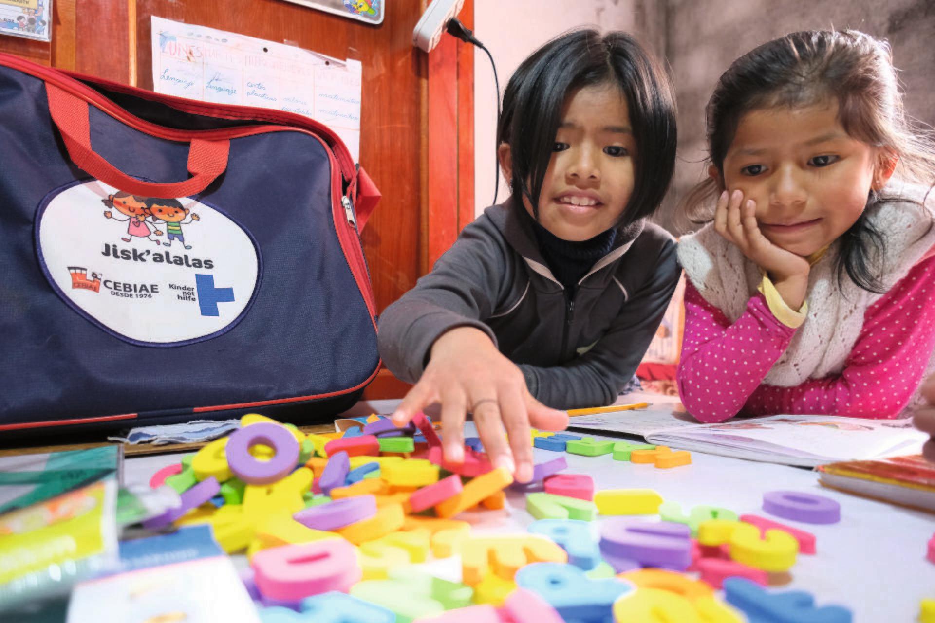 Zwei Kinder spielen mit Buchstabenmagneten (Quelle: Kindernothilfe-Partner) Zwei Kinder spielen mit Buchstabenmagneten (Quelle: Kindernothilfe-Partner)