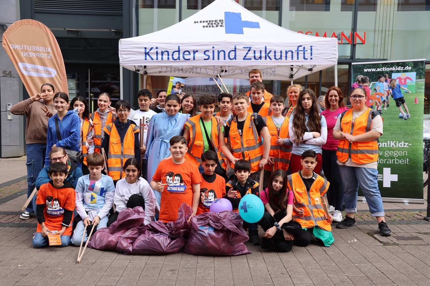 Eine Kindergruppe steht vor einem Kindernothilfe-Pavillon (Quelle: Ludwig Grunewald)