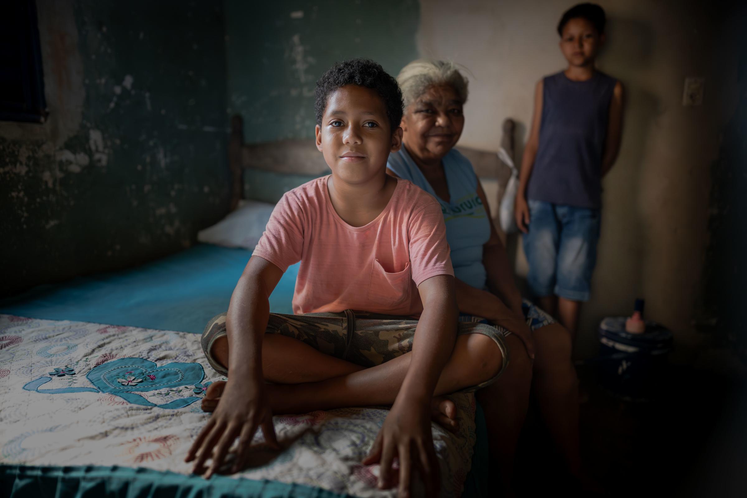 Ricardo sitzt auf seinem Bett und schaut in die Kamera. Foto: Jakob Studnar für KNH. Ricardo sitzt auf seinem Bett und schaut in die Kamera. Foto: Jakob Studnar für KNH.