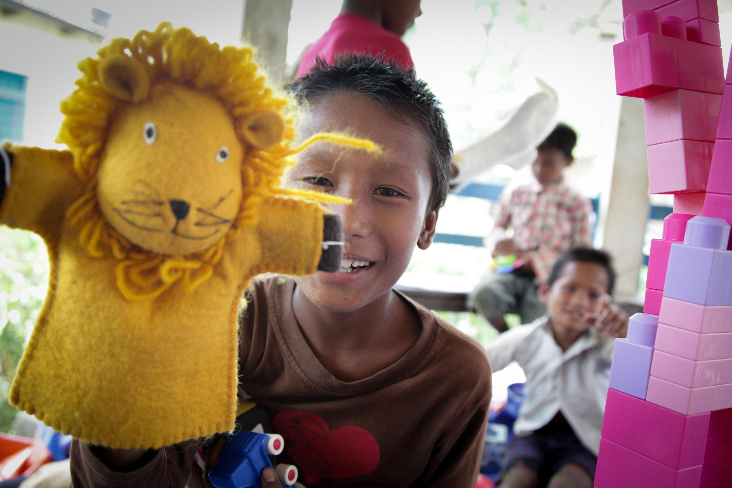 Ein Junge aus Nepal spielt mit einer Löwen-Handpuppe (Quelle: Bastian Strauch/Kindernothilfe) Ein Junge aus Nepal spielt mit einer Löwen-Handpuppe (Quelle: Bastian Strauch/Kindernothilfe)