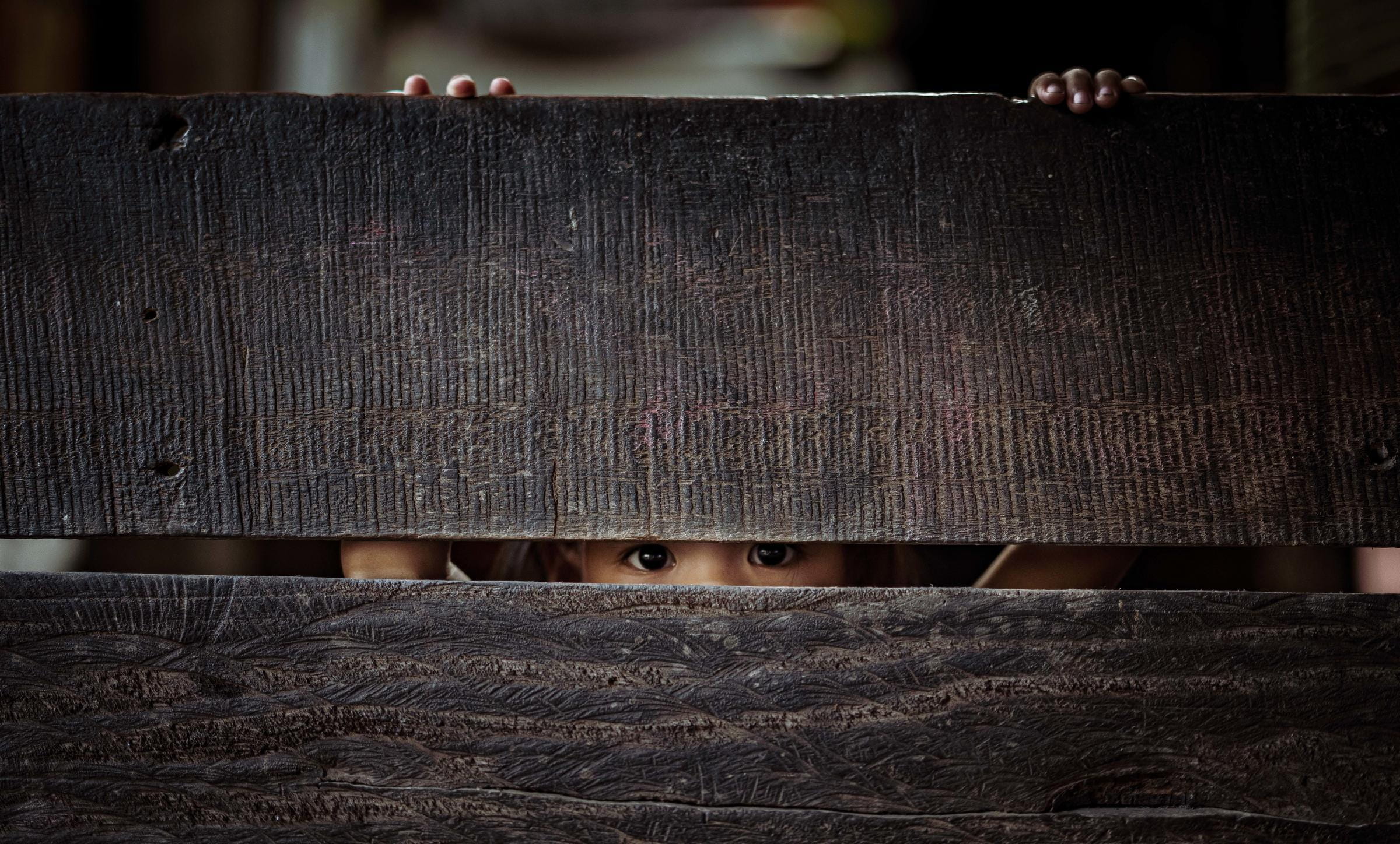 Ein Kind schaut durch einen Spalt; Foto: Jakob Studnar Ein Kind schaut durch einen Spalt; Foto: Jakob Studnar